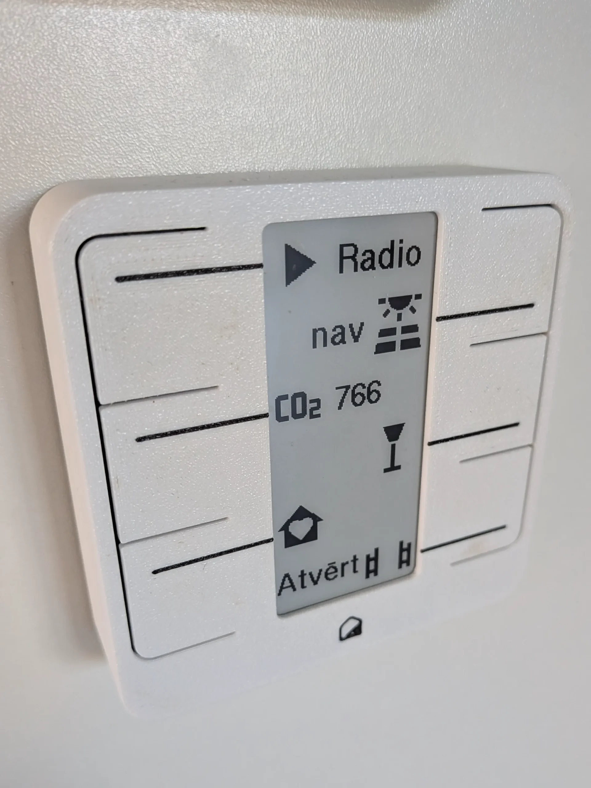 Home Buttons panelis ar sešām pogām radio, auto uzlādei, gaisa rādījumiem, TV gaismai, mājas režīmam un vārtiem